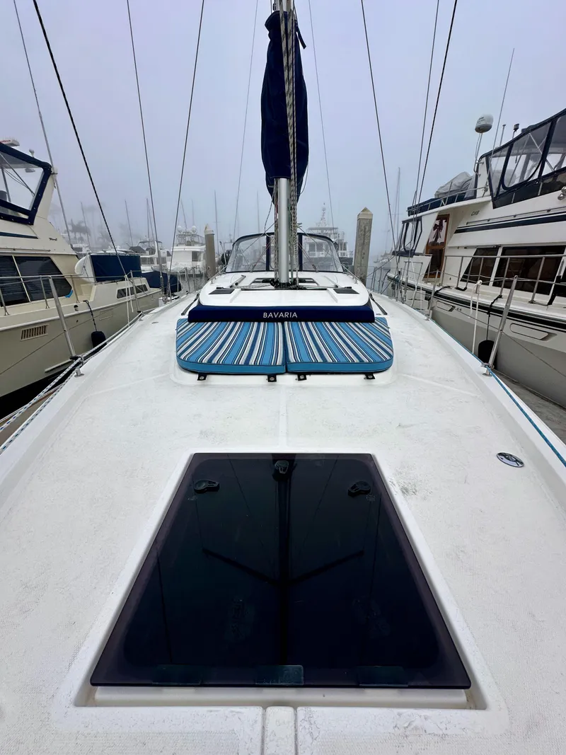 Slide: The Image of 2020 Bavaria C50 yacht deck with striped cushions, docked among other boats. - 19