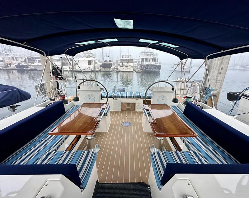 Slide: The Image of Luxurious 2020 Bavaria C50 yacht interior with elegant seating and wooden tables in a marina. - 24