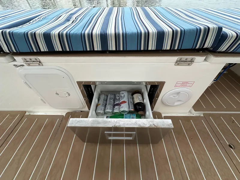 Slide: The Image of Bavaria C50 yacht with striped seating and open drawer containing beverages, 2020 model. - 34