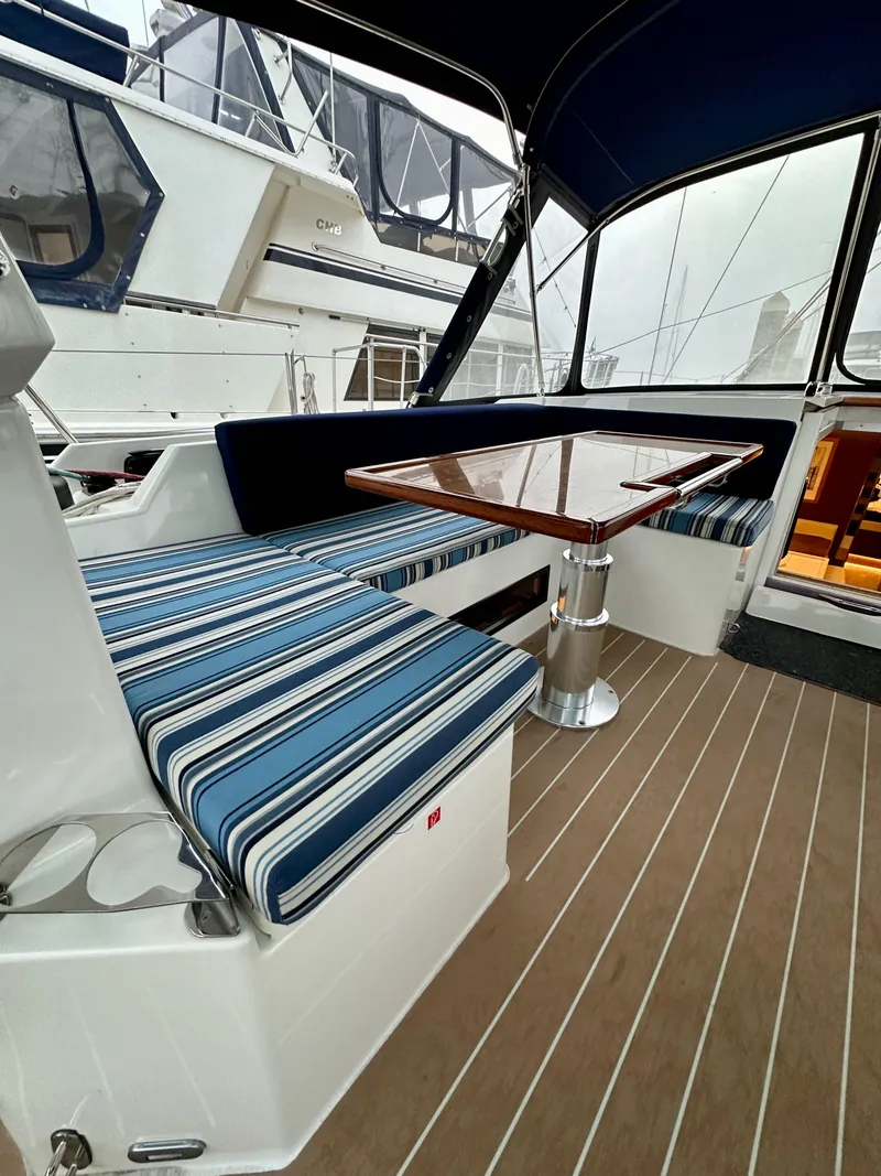 Slide: The Image of 2020 Bavaria C50 yacht interior with striped seating and wooden table. - 37