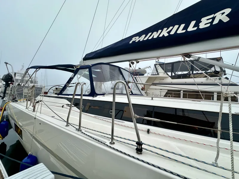 Slide: The Image of 2020 Bavaria C50 sailboat docked, featuring sleek design and "Painkiller" on the sail cover. - 9