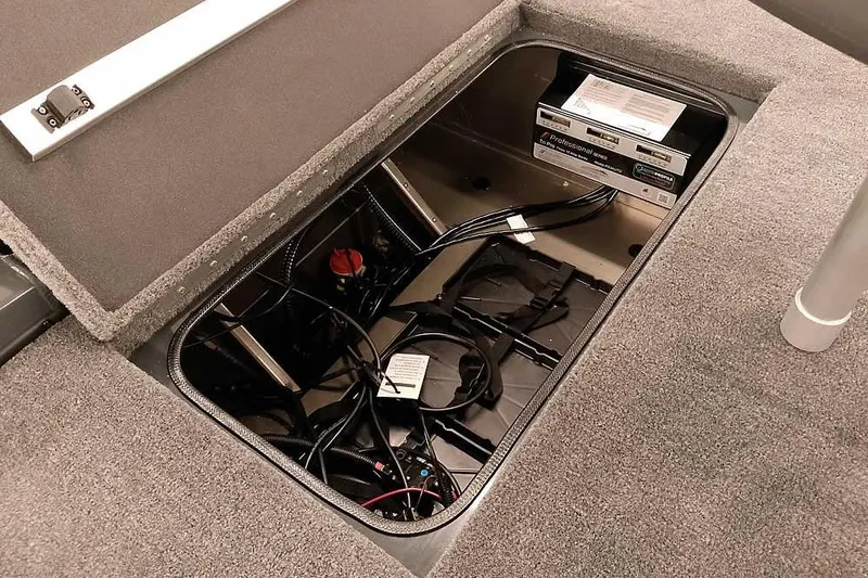 Slide: The Image of 2026 Ranger RT198P boat battery compartment with wiring and storage. - 30
