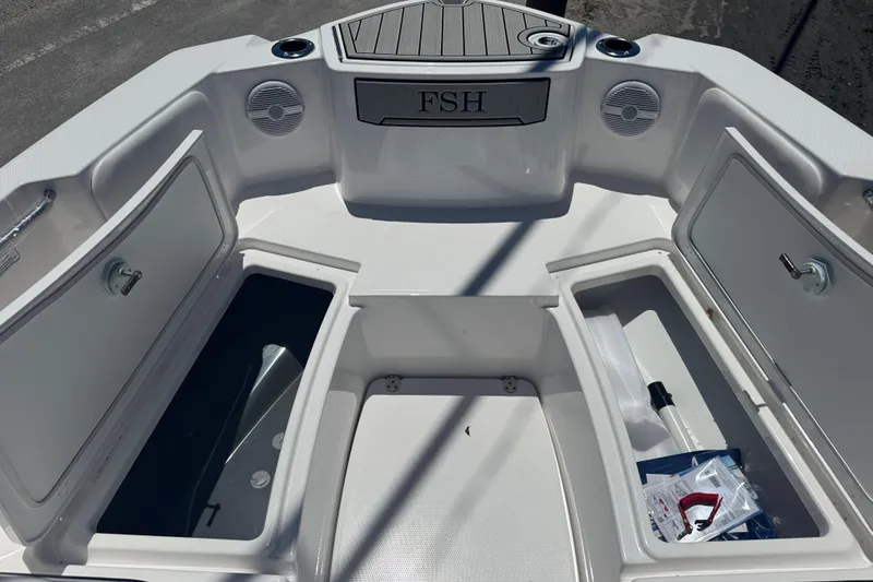 Slide: The Image of 2026 Yamaha Boats 220 FSH Sport interior with open storage compartments and speakers. - 9