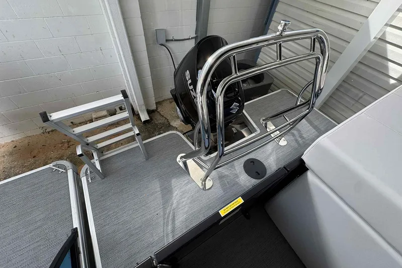 Slide: The Image of 2025 Sweetwater 2086 CSE boat with ladder and motor, docked indoors. - 5