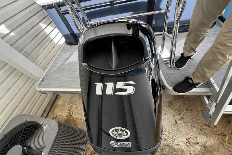 Slide: The Image of 2025 Sweetwater 2086 CSE boat with 115 horsepower engine, docked with person standing nearby. - 7