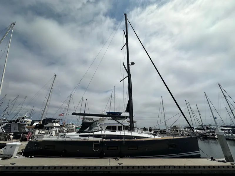 Slide: The Image of 2018 Jeanneau 54 sailboat docked at a marina under cloudy skies. - 13