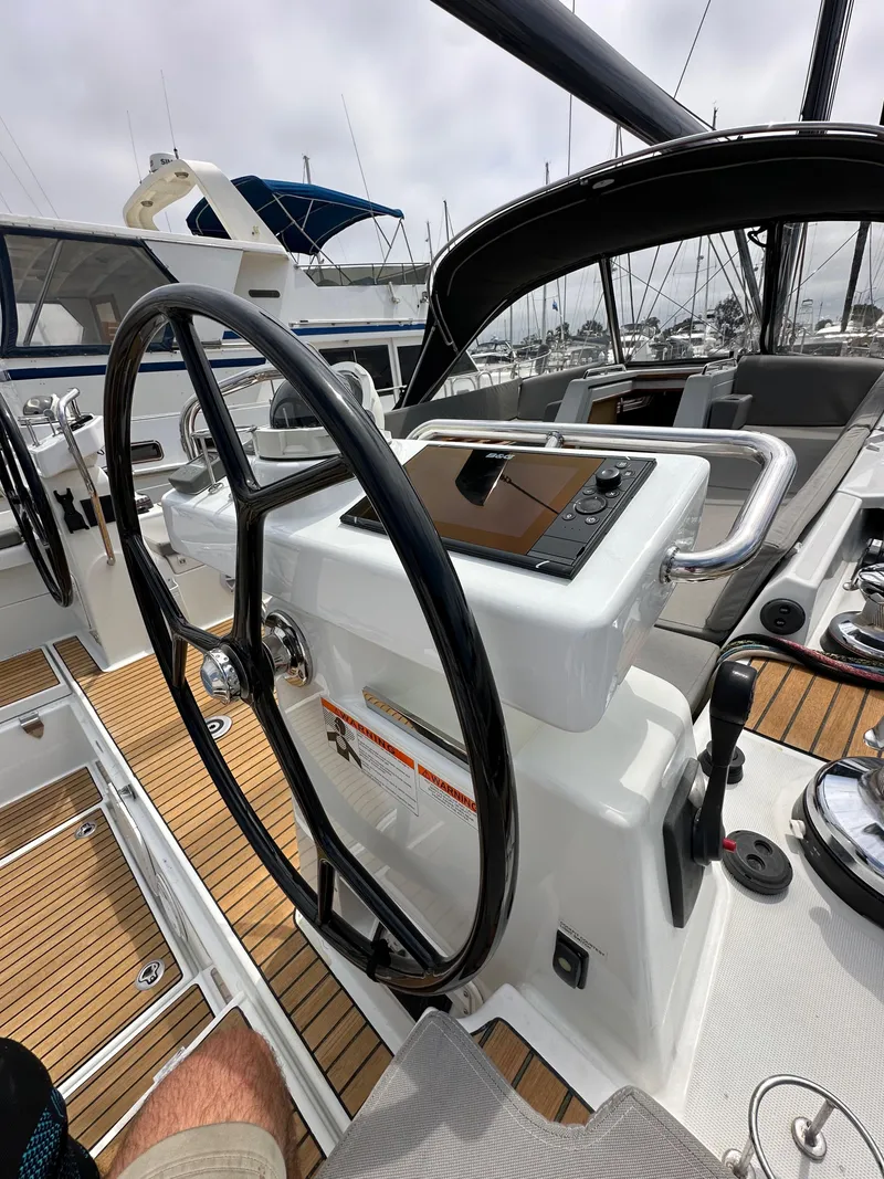 Slide: The Image of Steering wheel and controls of a 2018 Jeanneau 54 yacht, featuring teak decking. - 37
