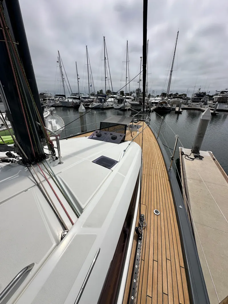 Slide: The Image of Jeanneau 54 sailboat, 2018 model, docked in marina with wooden deck and overcast sky. - 45