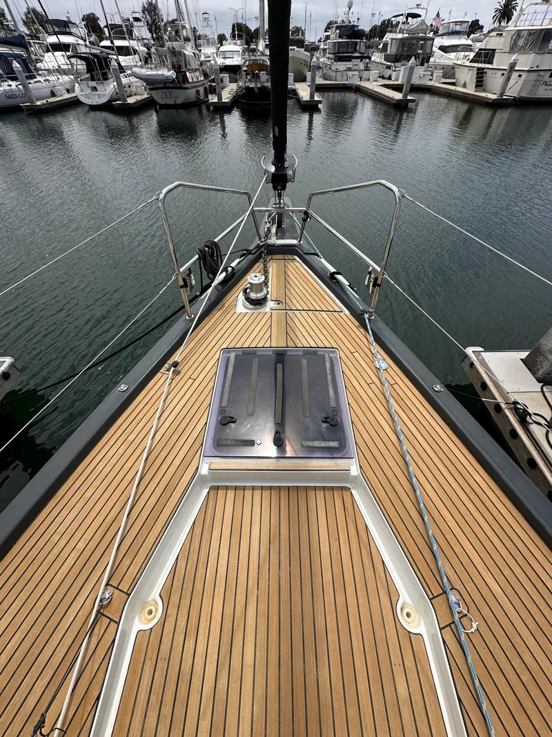 Slide: The Image of 2018 Jeanneau 54 yacht bow with teak deck, docked in marina. - 47
