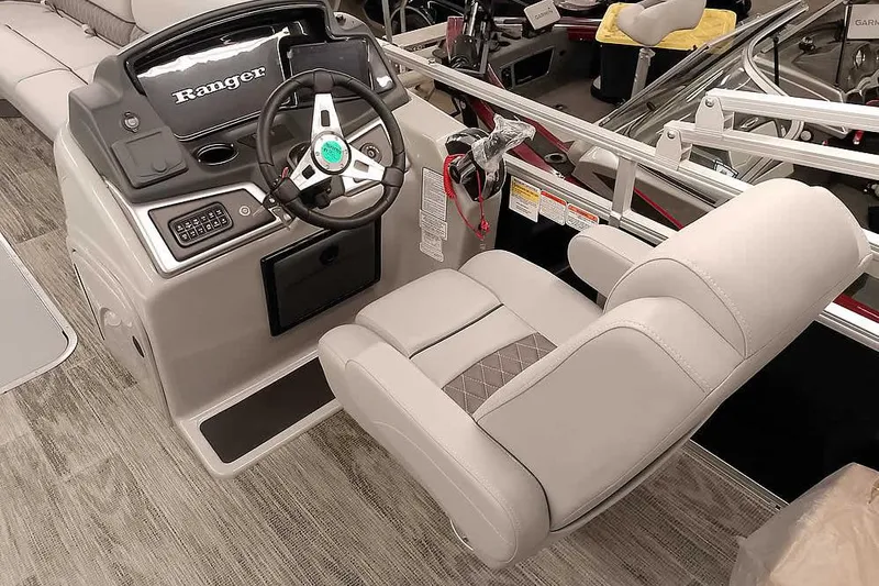 Slide: The Image of 2024 Ranger Reata 223C boat interior with steering wheel and captain's chair. - 12