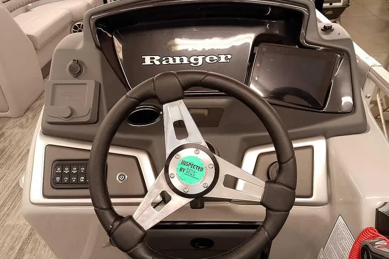 Slide: The Image of 2024 Ranger Reata 223C boat dashboard with steering wheel and control panel. - 14