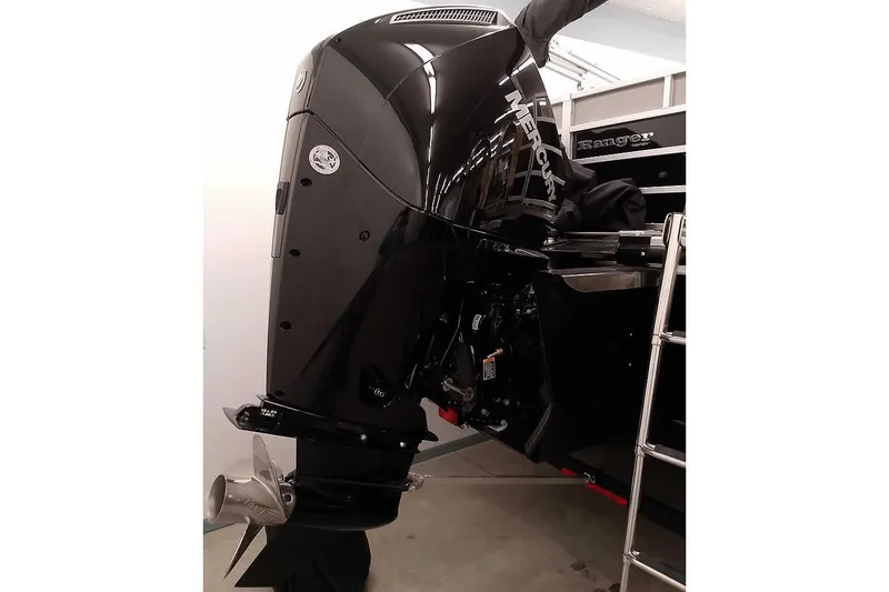 Slide: The Image of 2024 Ranger Reata 223C boat with a powerful Mercury outboard motor in a showroom. - 3