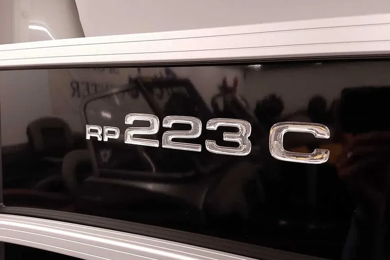 Slide: The Image of Close-up of 2024 Ranger Reata 223C model emblem on a sleek black surface. - 5