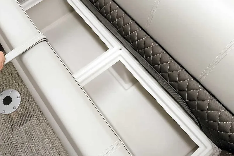 Slide: The Image of 2024 Ranger Reata 223C boat storage compartment with quilted upholstery and durable flooring. - 9