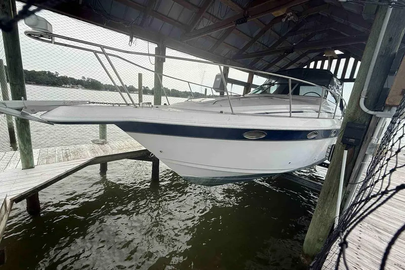 Slide: The Image of 2002 Donzi Z 32 EXPRESS boat docked under a wooden shelter by the water. - 5