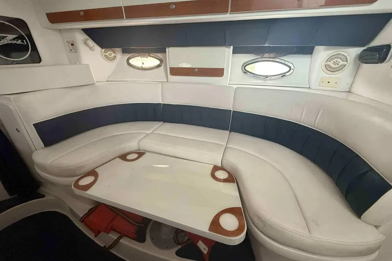 Slide: The Image of 2002 Donzi Z 32 EXPRESS interior with white and blue seating, oval windows, and a table. - 7