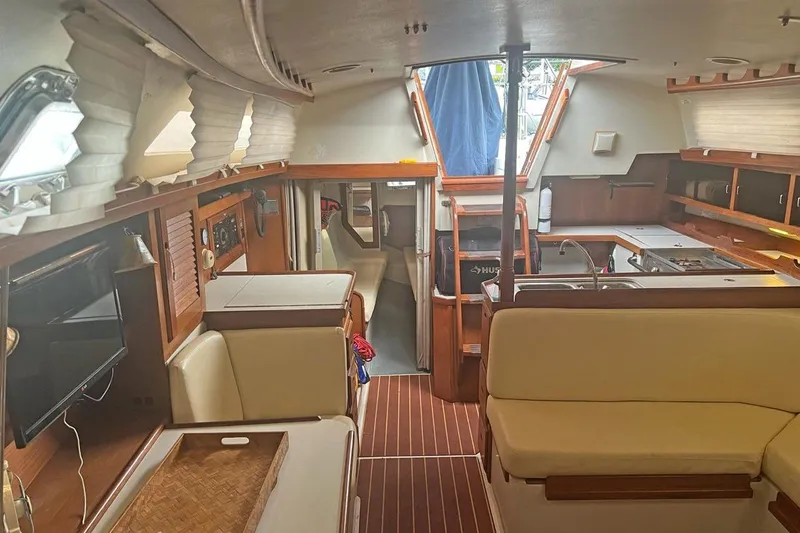 Slide: The Image of Interior of a 1992 Catalina Sloop sailboat with cozy seating and wooden finishes. - 11