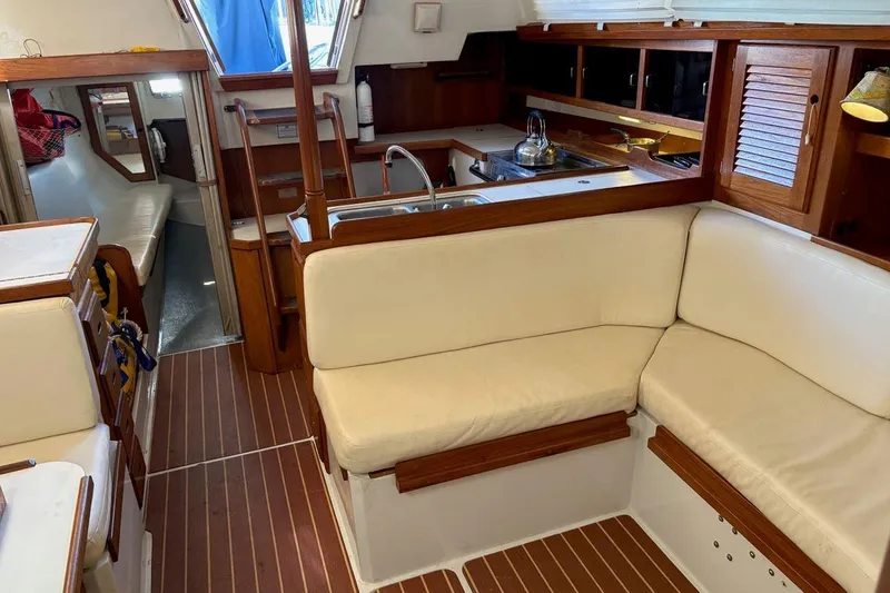 Slide: The Image of Interior of a 1992 Catalina Sloop sailboat with wood accents and white seating. - 12