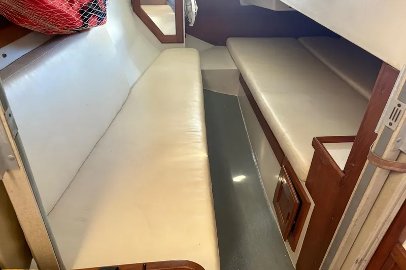 Slide: The Image of Interior of a 1992 Catalina Sloop sailboat with white cushioned seating. - 17