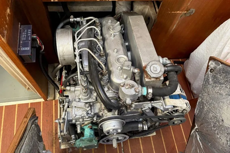 Slide: The Image of Engine of a 1992 Catalina Sloop sailboat, showcasing mechanical components and wooden surroundings. - 18