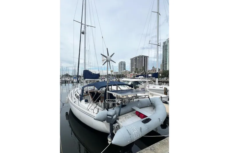 Slide: The Image of Catalina Sloop 1992 docked at marina with city skyline in background. - 3