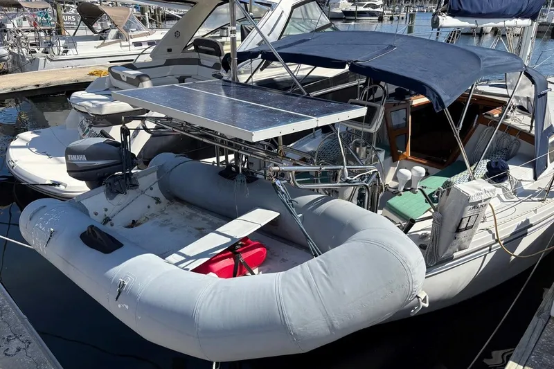 Slide: The Image of 1992 Catalina Sloop with solar panel and inflatable dinghy at marina. - 4