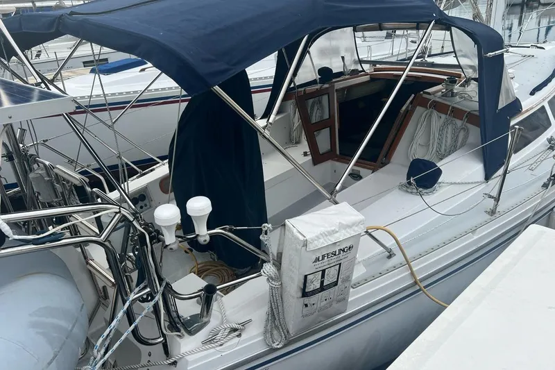 Slide: The Image of 1992 Catalina Sloop sailboat with blue canopy docked at marina. - 6
