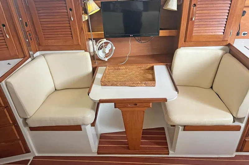 Slide: The Image of Cozy dining area in 1992 Catalina Sloop with wooden accents and cushioned seating. - 9