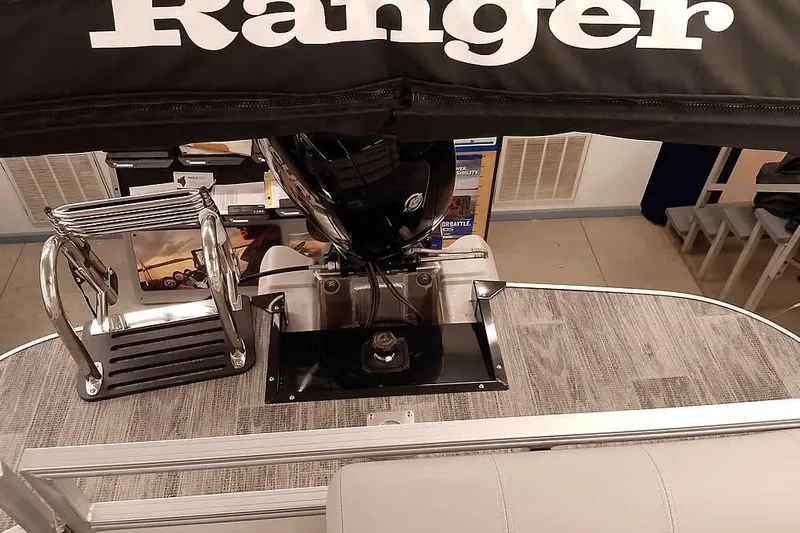 Slide: The Image of 2025 Ranger Reata 220C boat interior with motor and ladder, showroom display. - 11