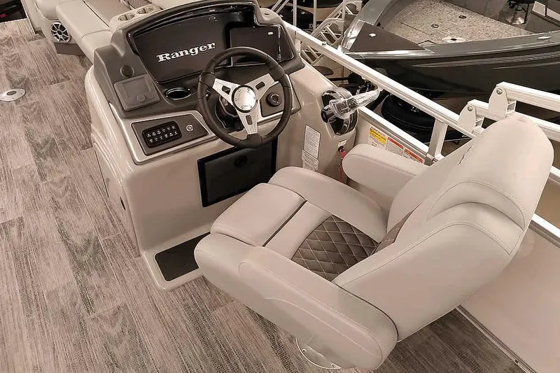 Slide: The Image of 2025 Ranger Reata 220C boat interior with steering console and plush captain's chair. - 12
