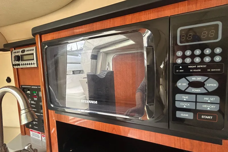 Slide: The Image of Interior of 2007 Sea Ray 240 Sundancer with Sylvania microwave and control panel. - 15