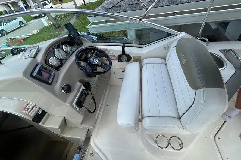 Slide: The Image of 2007 Sea Ray 240 Sundancer cockpit with steering wheel, gauges, and white seating. - 20