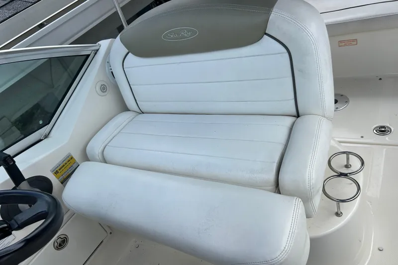 Slide: The Image of White leather seating on 2007 Sea Ray 240 Sundancer boat, featuring cup holders and steering wheel. - 21