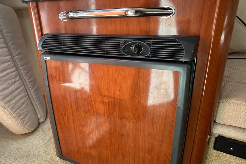 Slide: The Image of Wood-paneled mini fridge in 2007 Sea Ray 240 Sundancer boat interior. - 30