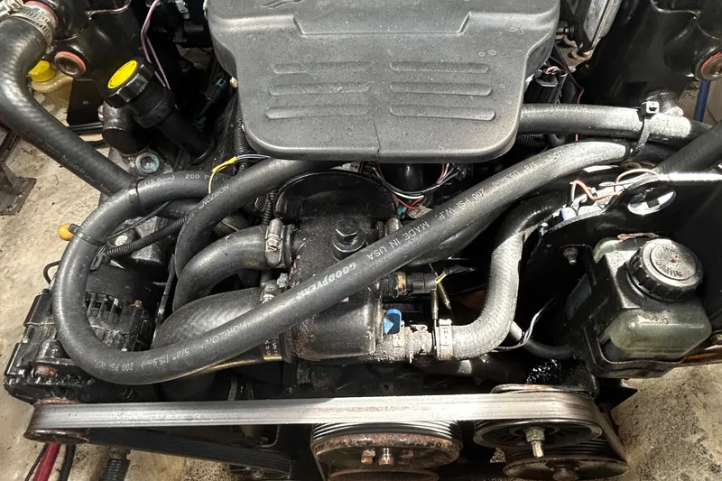 Slide: The Image of Engine of a 2007 Sea Ray 240 Sundancer boat, showcasing hoses and components. - 32