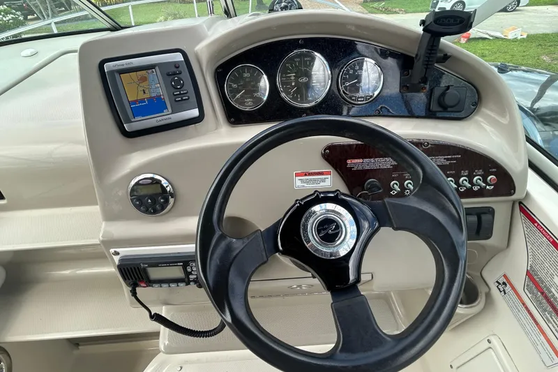 Slide: The Image of 2007 Sea Ray 240 Sundancer dashboard with steering wheel, gauges, and Garmin GPS. - 40