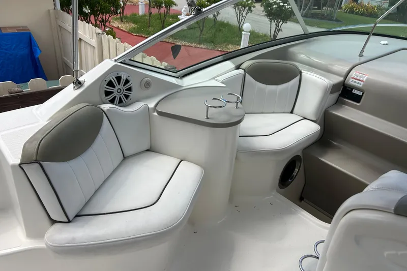 Slide: The Image of Interior of a 2007 Sea Ray 240 Sundancer boat with white seating and cup holders. - 42