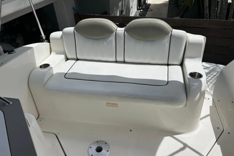 Slide: The Image of 2007 Sea Ray 240 Sundancer boat seating area with cup holders, white upholstery. - 43