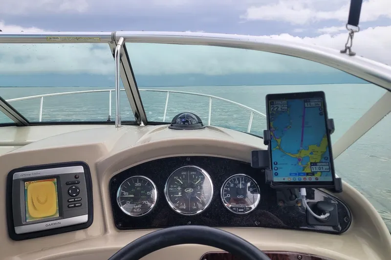 Slide: The Image of 2007 Sea Ray 240 Sundancer dashboard with GPS and navigation instruments on open water. - 53