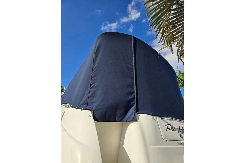 Slide: The Image of 2007 Sea Ray 240 Sundancer boat with blue cover under clear sky. - 56