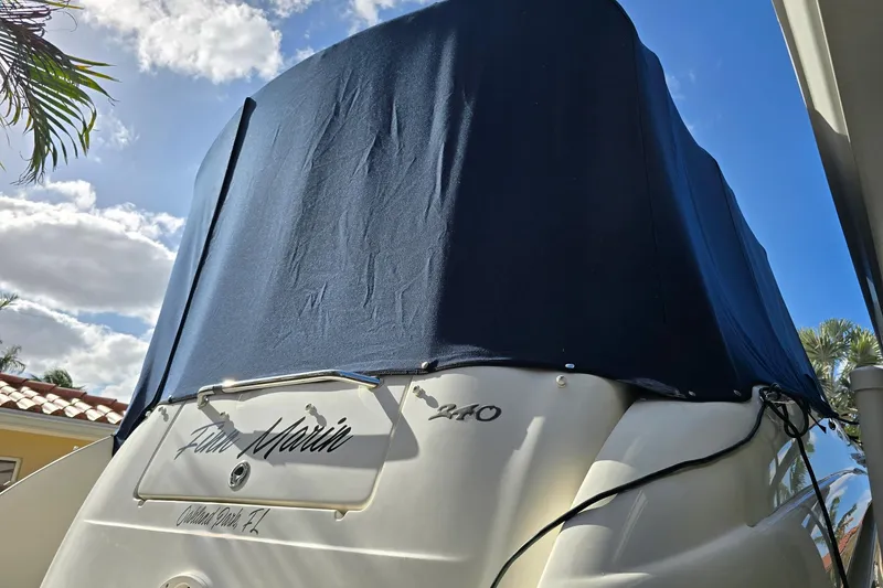 Slide: The Image of 2007 Sea Ray 240 Sundancer boat with cover, under a sunny sky. - 57