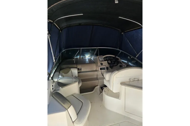 Slide: The Image of 2007 Sea Ray 240 Sundancer boat interior with seating and steering wheel. - 58