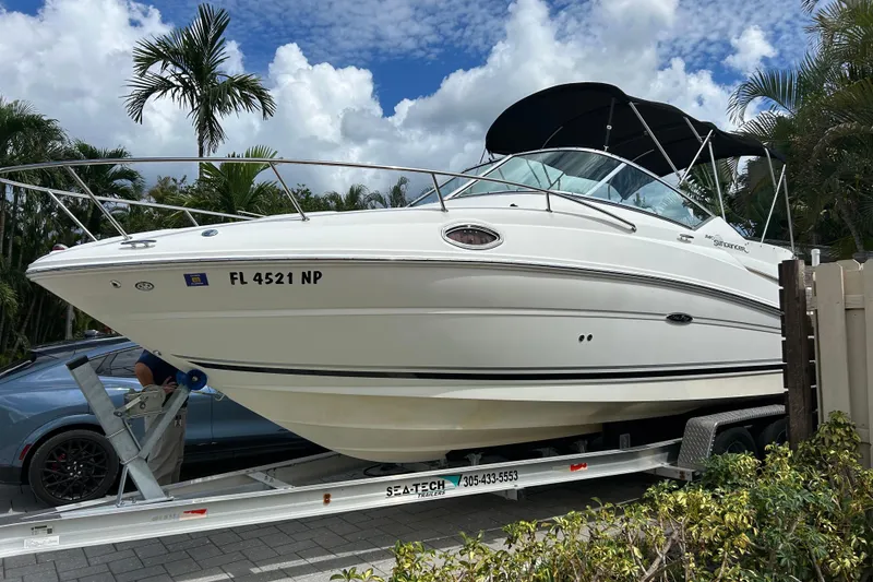 Slide: The Image of 2007 Sea Ray 240 Sundancer boat on trailer, surrounded by palm trees and blue sky. - 7