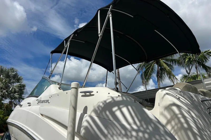 Slide: The Image of 2007 Sea Ray 240 Sundancer boat with canopy, set against a tropical sky. - 8