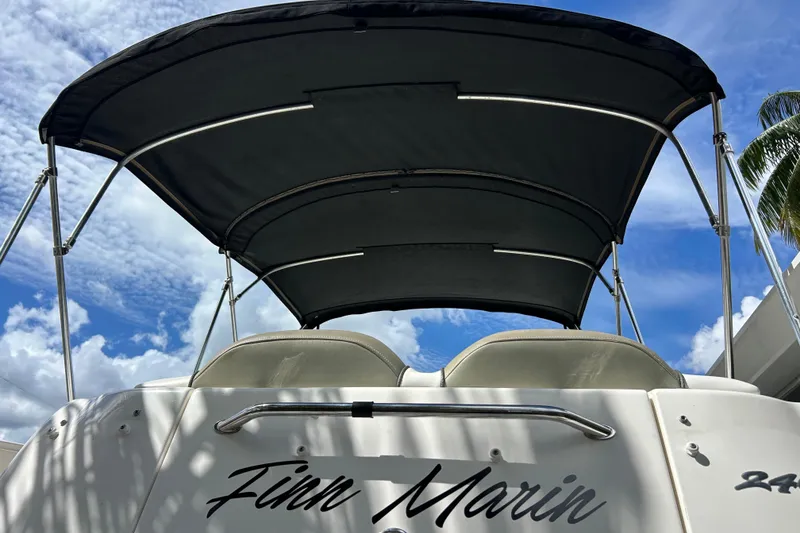 Slide: The Image of 2007 Sea Ray 240 Sundancer boat with canopy under a blue sky. - 9