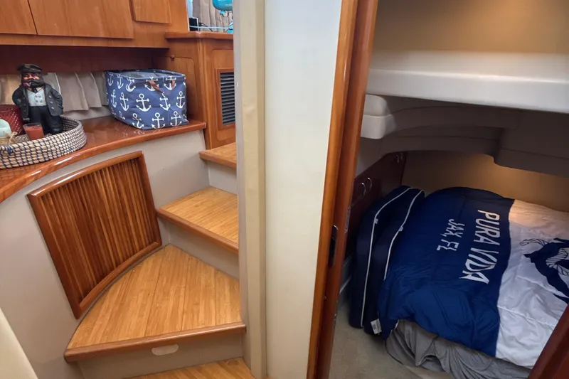 Slide: The Image of Interior of 2005 Carver 36 Sedan with wooden stairs and cozy cabin bed. - 14