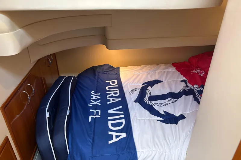 Slide: The Image of Cozy cabin interior of 2005 Carver 36 Sedan with nautical-themed bedding. - 15