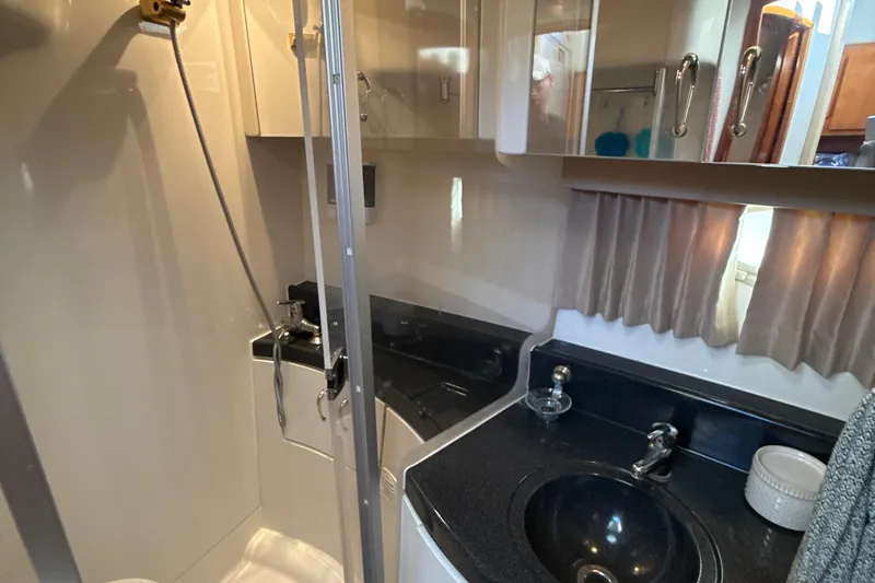 Slide: The Image of 2005 Carver 36 Sedan bathroom with shower, sink, and storage cabinets. - 17