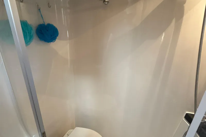 Slide: The Image of Shower area inside 2005 Carver 36 Sedan, featuring blue bath sponges. - 18