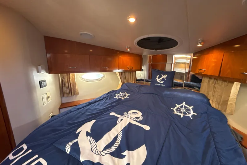 Slide: The Image of Interior of 2005 Carver 36 Sedan with nautical-themed bedding and wooden cabinets. - 20
